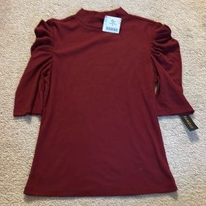 Wine colored, 3/4 sleeve top with ruched sleeves.